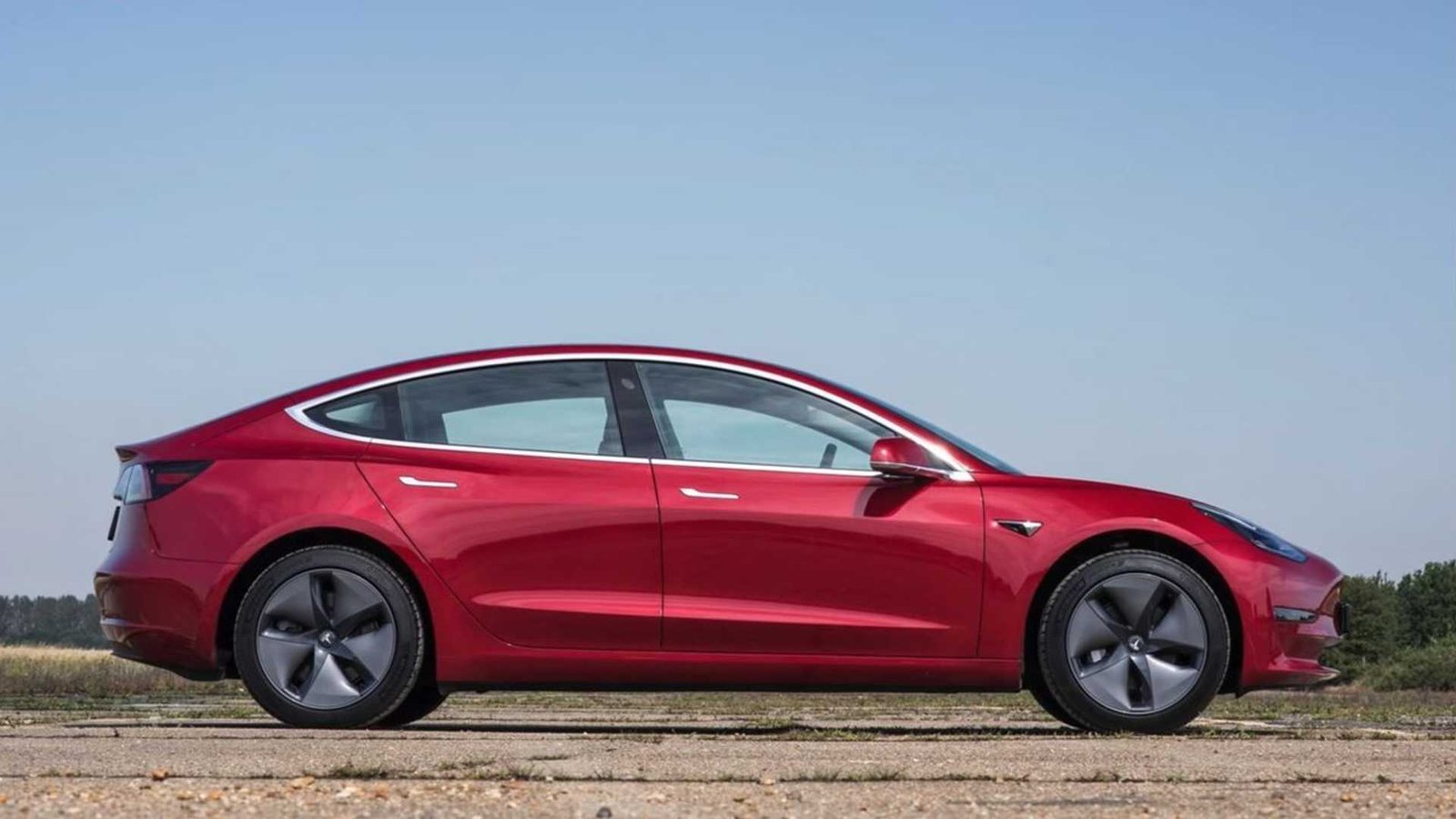 1640891920 tesla model 3 red side view